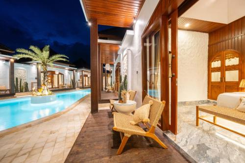 a villa with a swimming pool and a bedroom at Casa Maddu in Tegalalang