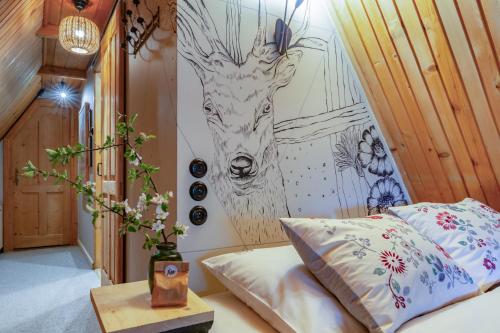 a bedroom with a bed and a painting of a giraffe at Leśniczówka u Zięby in Kościelisko
