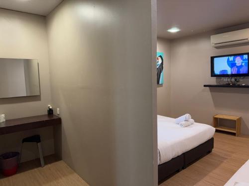 a hotel room with a bed and a tv at Baliyana Le Lodge in Kuantan