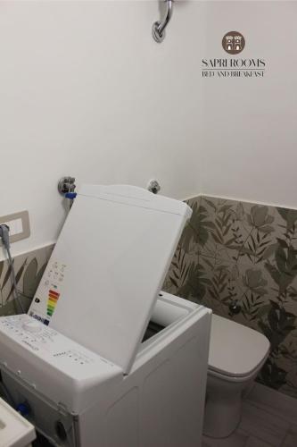 a white sink in a bathroom with a toilet at Sapri Rooms in Lamezia Terme