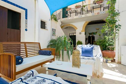 a patio with chairs and a table and a balcony at Roccamelia Experience in Mazara del Vallo