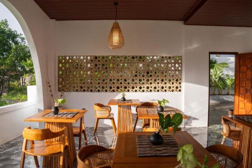 a restaurant with tables and chairs and a wall of wine bottles at Casa Maddu in Tegalalang