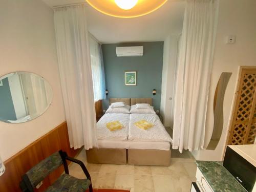 a small bedroom with two beds and a mirror at Angéla Vendégház in Zalakaros