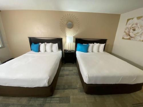 two beds sitting next to each other in a hotel room at Stanford Inn & Suites Anaheim in Anaheim