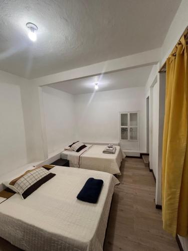 a room with three beds in it at Hotel Santa Marta Centro Histórico in Popayan
