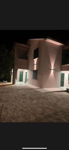 a white building with green doors and lights on it at Villa Vida, Medulin - Bazen i jacuzzi in Medulin