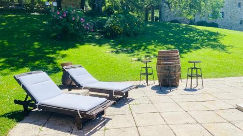 two chairs and a table in a yard at La Bastide de Marie & Pascal in Larroque