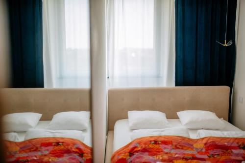 two beds in a room with a mirror at Apartament w Centrum z widokiem na Stare Miasto Zamość in Zamość