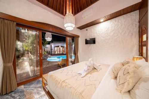a bedroom with a large white bed in a room at Casa Maddu in Tegalalang