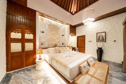 a bedroom with a large white bed in a room at Casa Maddu in Tegalalang