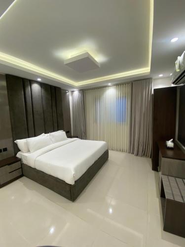 a bedroom with a large white bed in a room at سيتي قولد للشقق الفندقيه in Taif