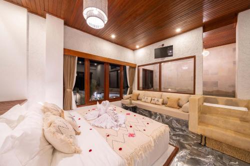 a bedroom with a large bed and a couch at Casa Maddu in Tegalalang