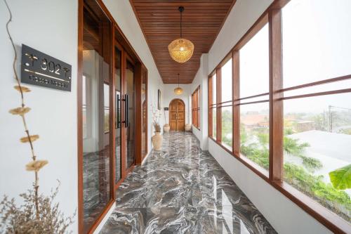 a hallway with a marble floor and large windows at Casa Maddu in Tegalalang