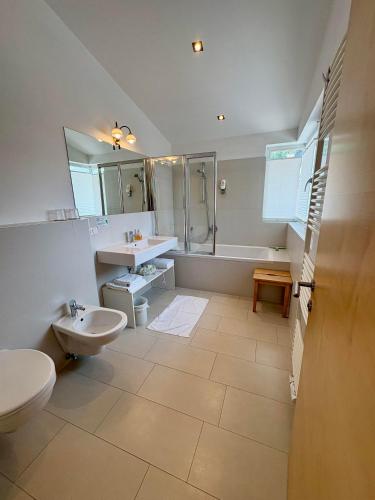 a bathroom with a sink and a toilet and a tub at Garni Apparthotel St Valentin in San Valentino alla Muta