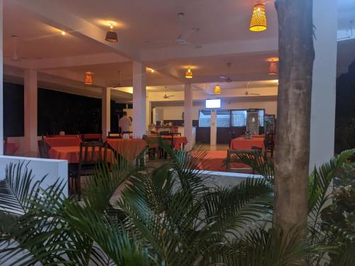 ナングウィにあるKivulini Lodge and Restaurantの赤いテーブルと椅子と人が置かれたレストラン