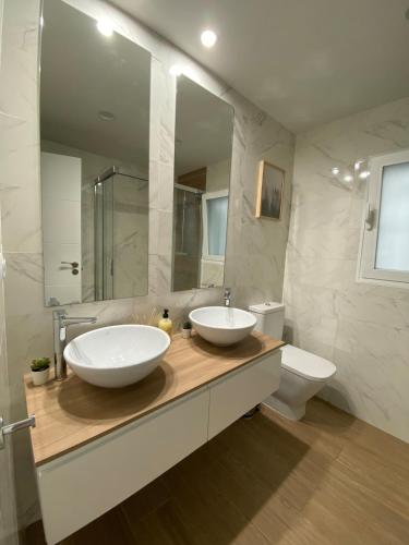 a bathroom with two sinks and a toilet at Alojamiento - Las Murallas de Dulcinea in Avila