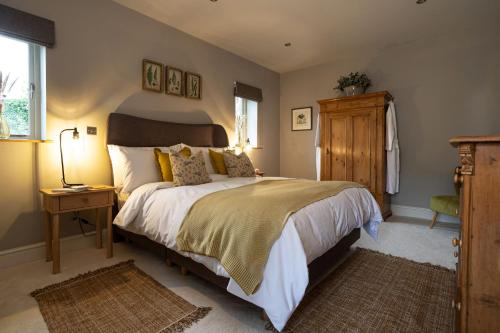 a bedroom with a large bed and a wooden cabinet at Hen Harrier Lodge in Lancaster