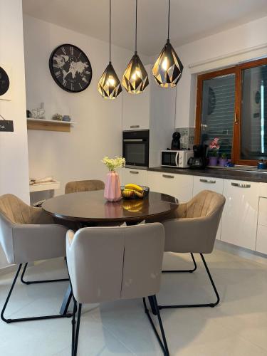 a kitchen with a table and chairs and a clock at Villa Vida, Medulin - Bazen i jacuzzi in Medulin