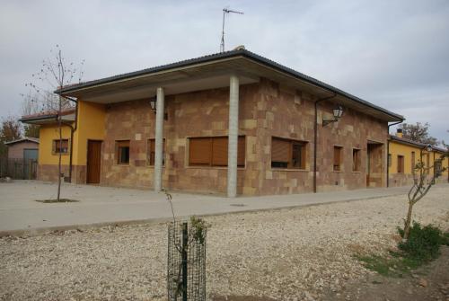a large brick building with boarded up windows at Bungalows Granja Escuela Arlanzón in Arlanzón