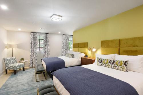a hotel room with two beds and a chair at Double Queen Suite 2nd Floor Downtown Savannah in Savannah