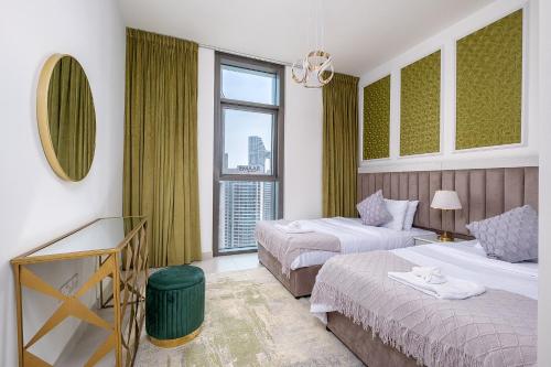 a hotel room with two beds and a window at Stylish 2BR with Boulevard View & 5 min from Dubai Mall in Dubai