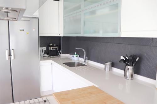 una cucina con mobili bianchi e un lavandino di Alojamiento Rural Casa Praillo - Priego de Córdoba - Zamoranos a Zamoranos