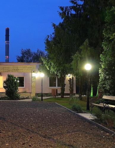 a building with two street lights and a bench at Clementine Apartman in Százhalombatta