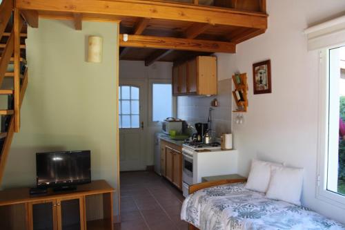 Una cocina con un sofá y un televisor en una habitación. en Esquel Apart Loft, en Esquel