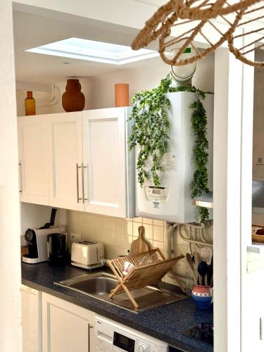 a kitchen with white cabinets and a sink at Gure Zoriona, Petit Bonheur en basque in Biarritz
