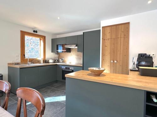 - une cuisine avec un comptoir et quelques chaises dans l'établissement Jardin des Eduits Serre Chevalier Chantemerle, à Saint-Chaffrey