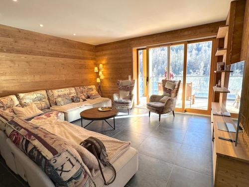 une chambre avec un lit, un canapé et une table dans l'établissement Jardin des Eduits Serre Chevalier Chantemerle, à Saint-Chaffrey