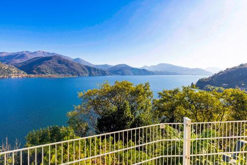 a view of a lake with a white fence at Casa Samara in Cannobio