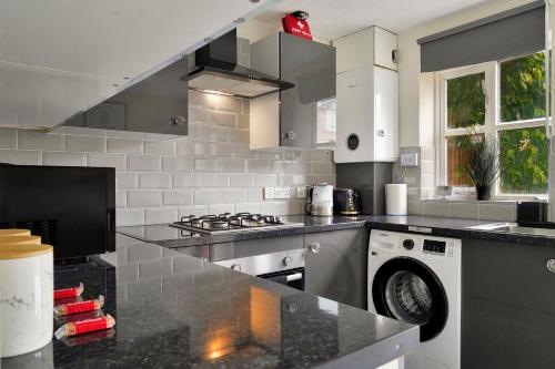 a kitchen with a stove and a dishwasher at Thames Family Retreat, 2 bed house, Sleeps 6, with Parking and Garden in Thamesmead