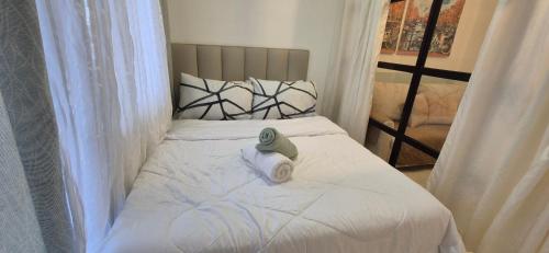 a bedroom with a bed with a towel on it at CozyNest Rentals at Brenthill Condominium in Baguio