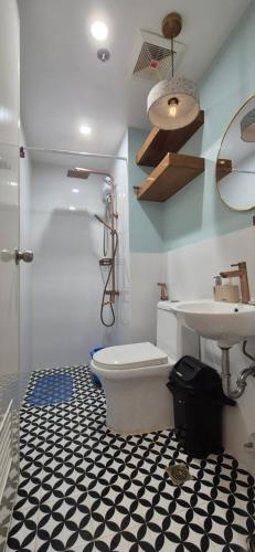 a bathroom with a toilet and a sink at CozyNest Rentals at Brenthill Condominium in Baguio