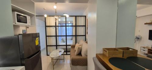 a kitchen and living room with a black refrigerator at CozyNest Rentals at Brenthill Condominium in Baguio
