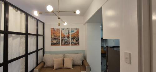 a living room with a couch and a painting on the wall at CozyNest Rentals at Brenthill Condominium in Baguio