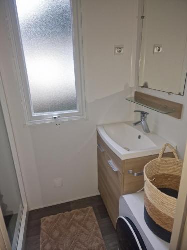 une salle de bain avec un lavabo et une fenêtre dans l'établissement Mobilhome chaleureux 8 couchages, à Pont-Aven