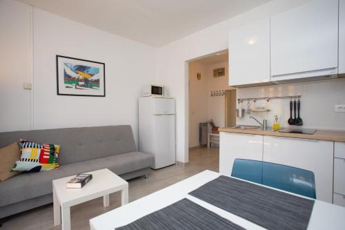 a living room with a couch and a kitchen at Lemechi Casa Belfior Apartments in Rabac