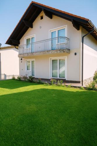 une maison avec une pelouse verte devant dans l'établissement Guesthouse Nestoria Living, à Banja Luka