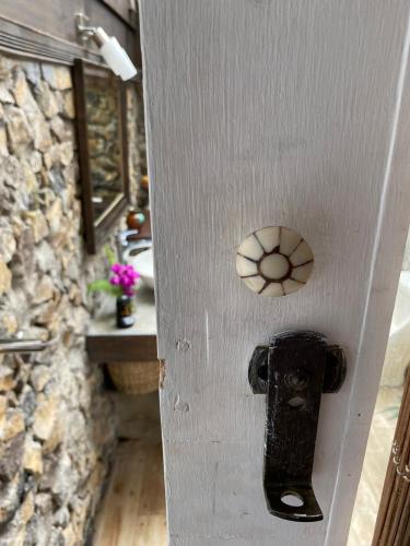 a door with a door knob on it with a stone wall at Jicote finca de ecoturismo in Cartago