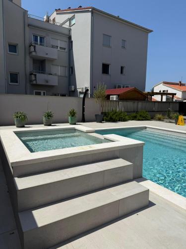 a swimming pool with stairs next to a building at Villa Vida, Medulin - Bazen i jacuzzi in Medulin
