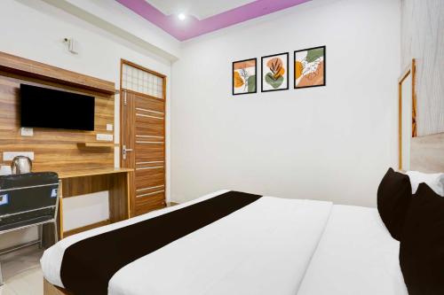a bedroom with a white bed and a tv at Collection O Sector 4 Gurgaon in Gurgaon