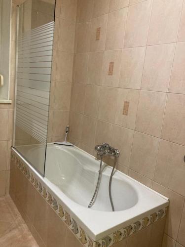 a bath tub with a faucet in a bathroom at Nice apartment in Celje in Celje
