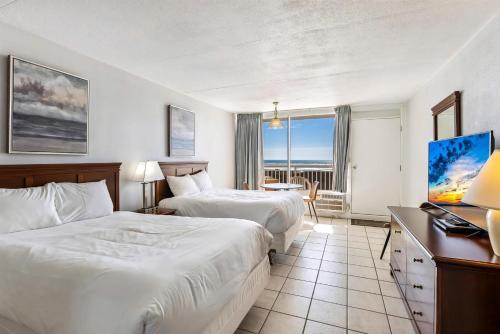 Una habitación de hotel con dos camas y un escritorio. en 6201 Ocean Ave, Unit 311 - The Nassau Inn, en Wildwood