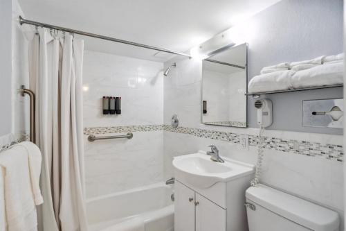 y baño blanco con lavabo, aseo y ducha. en 6201 Ocean Ave, Unit 409 - The Nassau Inn, en Wildwood