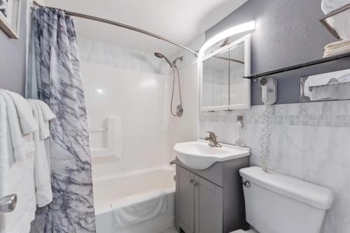Un baño con lavabo, inodoro y ducha. en 6201 Ocean Ave, Unit 503 - The Nassau Inn, en Wildwood