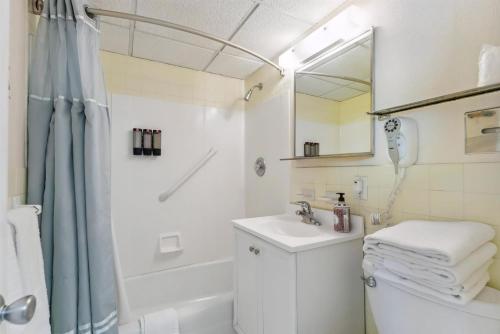 a white bathroom with a sink and a shower at 6201 Ocean Ave, Unit 505 - The Nassau Inn in Wildwood