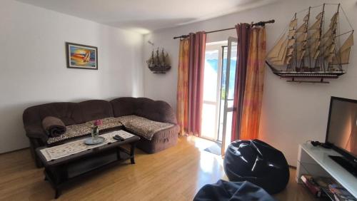 a living room with a brown couch and a tv at Stella Maris - Family Apartment in Polače