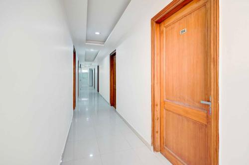 a hallway with a wooden door and white walls at Collection O Sector 135 Noida in Noida